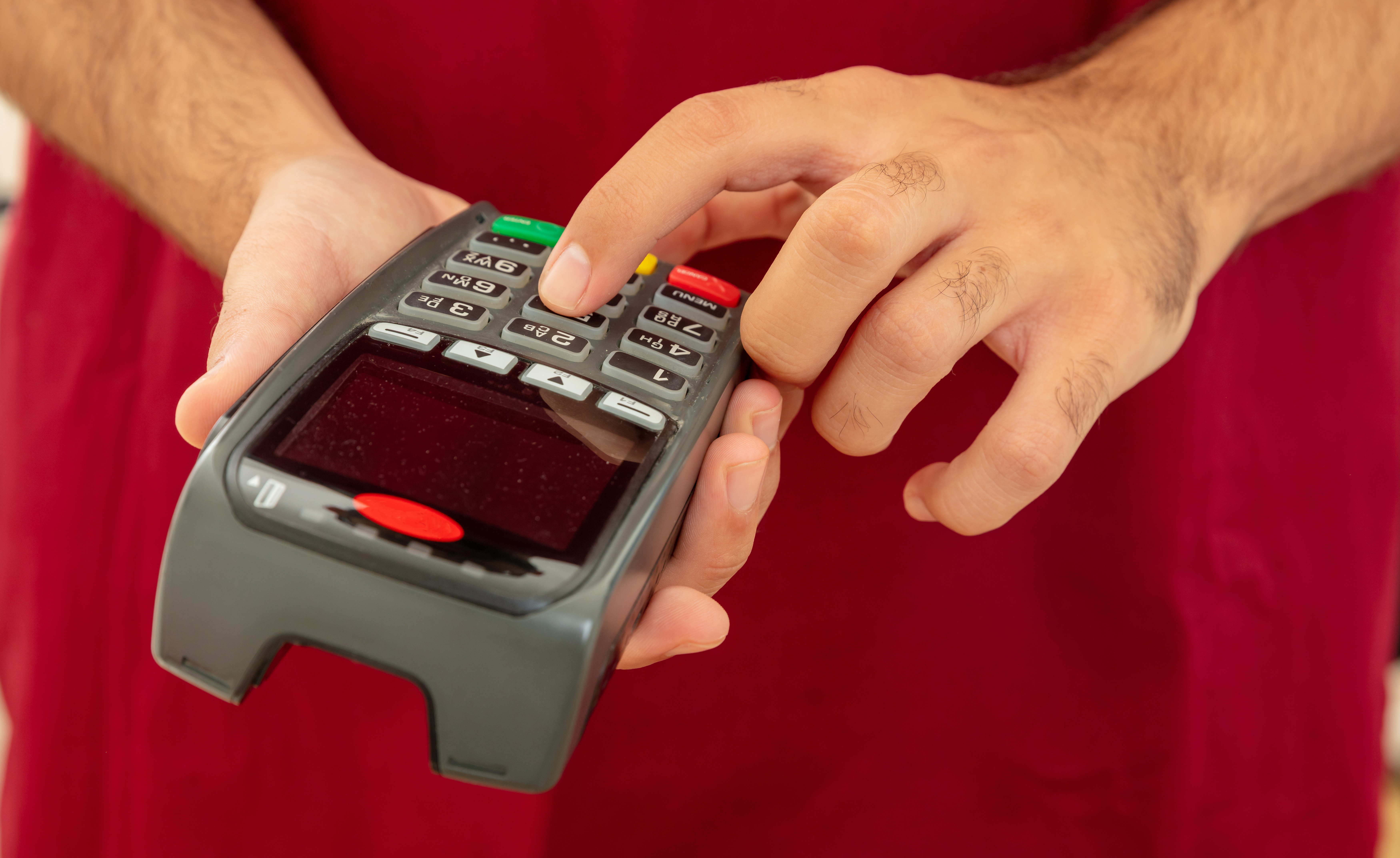 Man typing on a POS terminal, payment with credit card. Banking, shopping concept.
